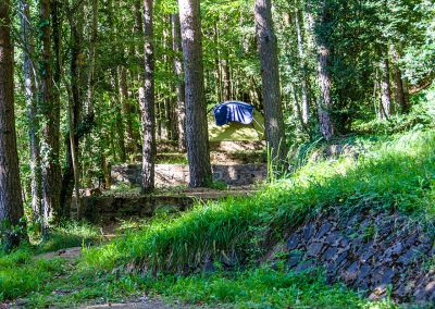 Camping en el Valle de Hecho Pirineos en una pradera de hierba natural: parcelas de diferentes tipos en el bosque entre pinos y hayas
